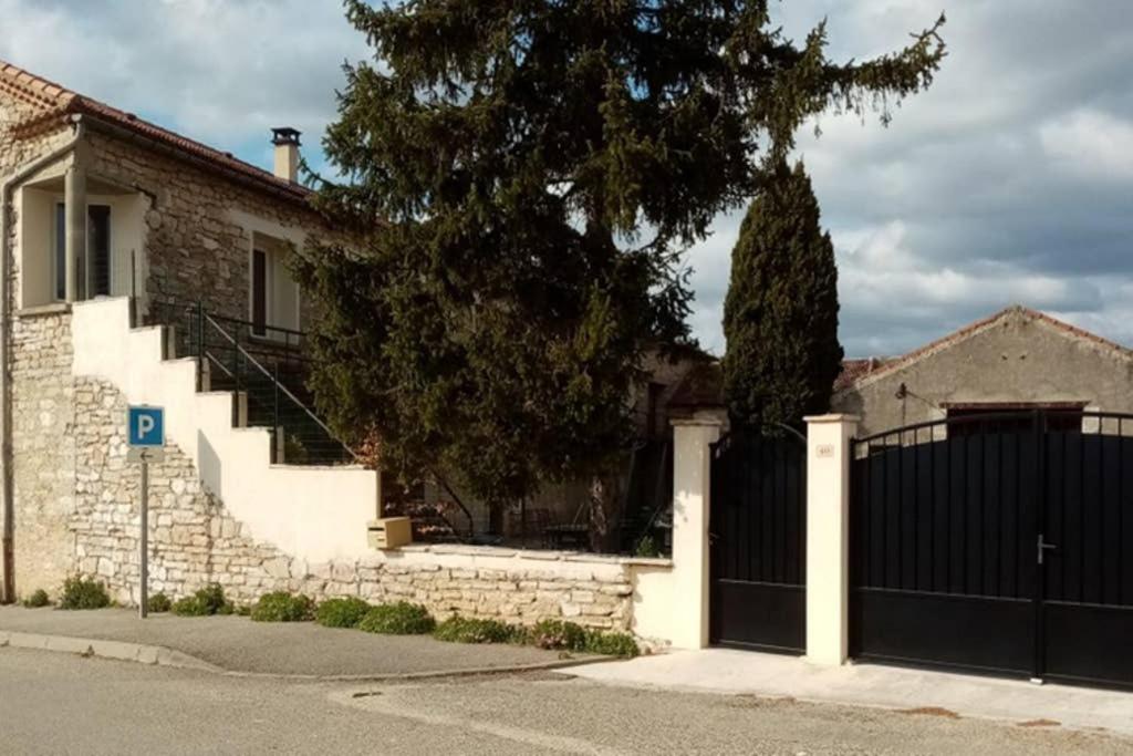 ein Haus mit einem schwarzen Zaun und einem Tor in der Unterkunft Gites de l'aven in Orgnac-lʼAven