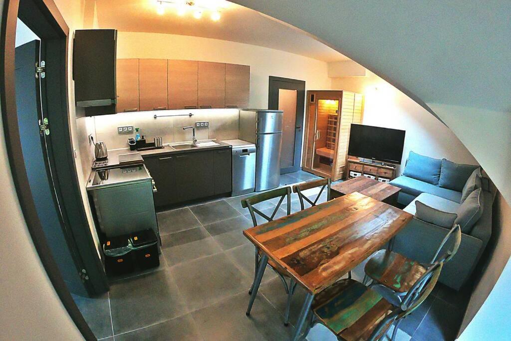 ein Wohnzimmer mit einem Tisch und einer Küche in der Unterkunft The Mountain Loft Klinovec - with infrasauna in Jáchymov