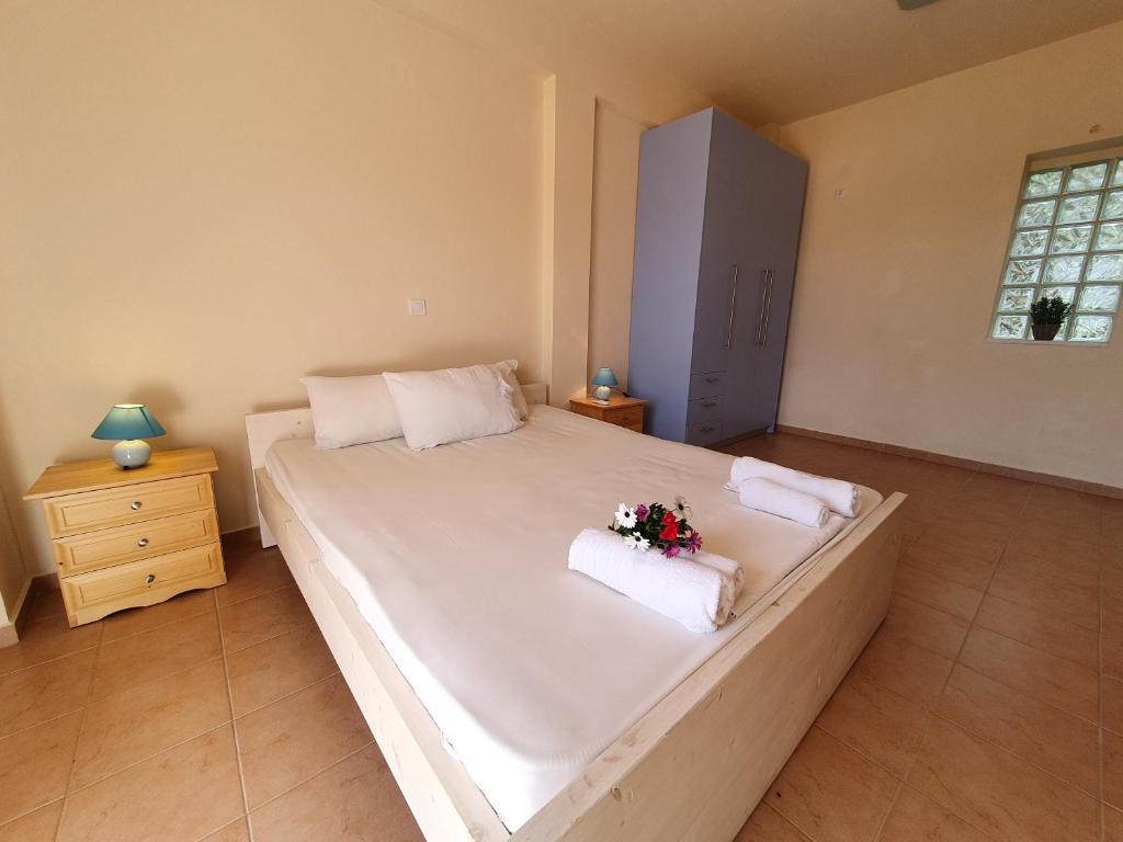 a bedroom with a large white bed with flowers on it at Stoupa Lefktro 2 in Stoupa