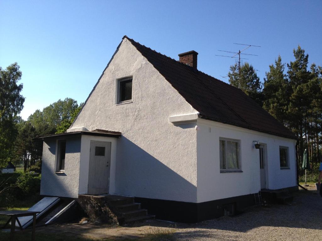 Glemminge的住宿－Österlencharm，黑色屋顶的白色房子