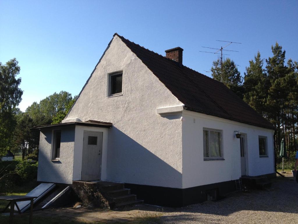 una casa blanca con techo negro en Österlencharm, en Glemminge