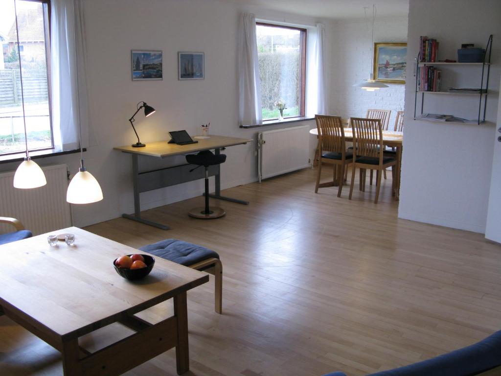 a living room with a table and a dining room at Fuglevænget in Hundested