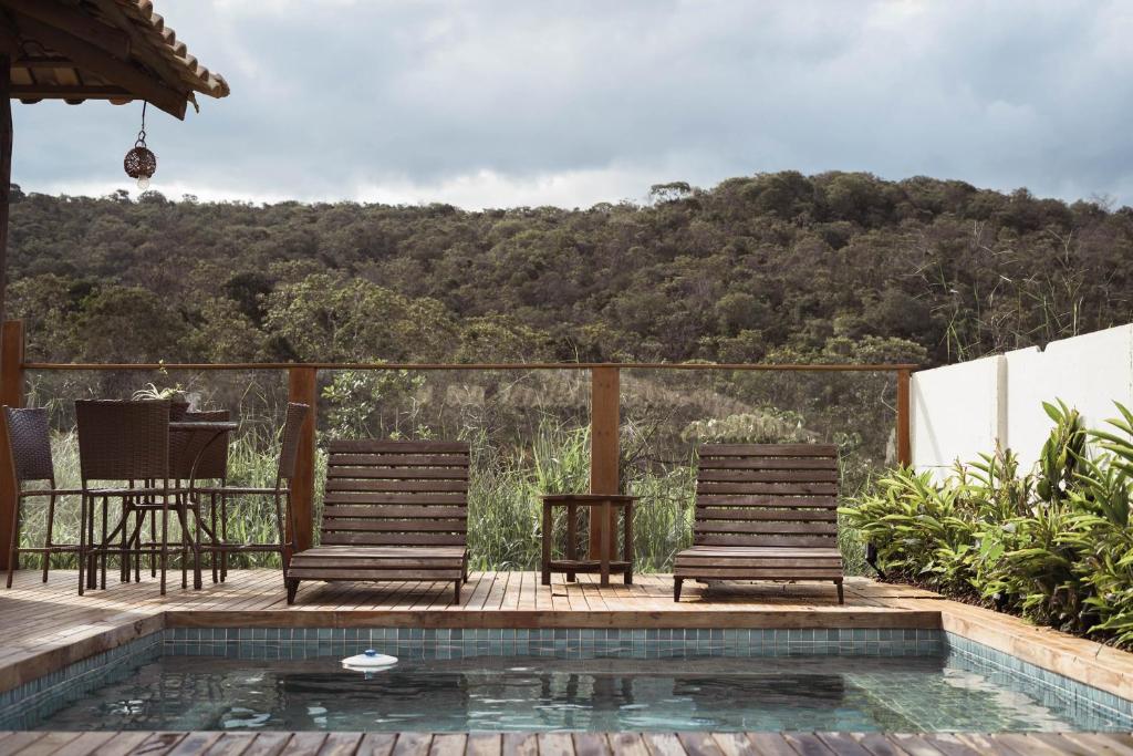 twee stoelen op een terras naast een zwembad bij Vila Gaia Guest House in Alto Paraíso de Goiás