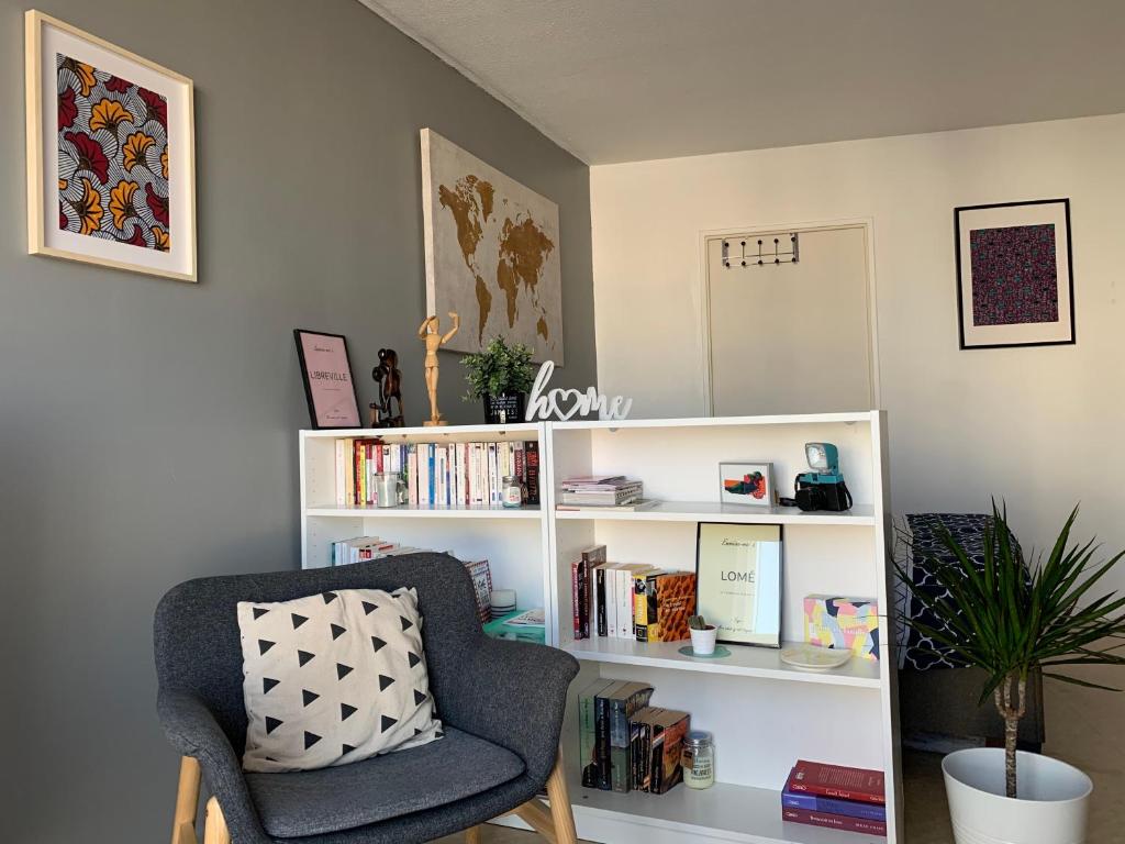 salon z krzesłem i półkami na książki w obiekcie Woézon Na Mi w mieście Lyon