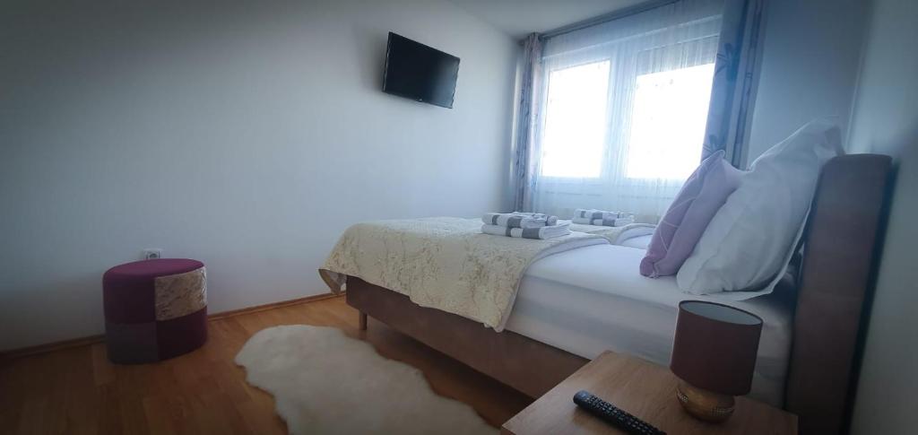 sypialnia z łóżkiem z oknem i dywanem w obiekcie Apartment Mia -V w Zagrzebiu