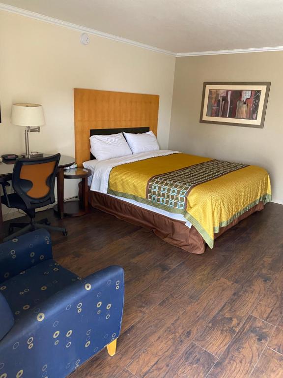 a hotel room with a bed and a desk and a chair at Great Western Inn in Junction City