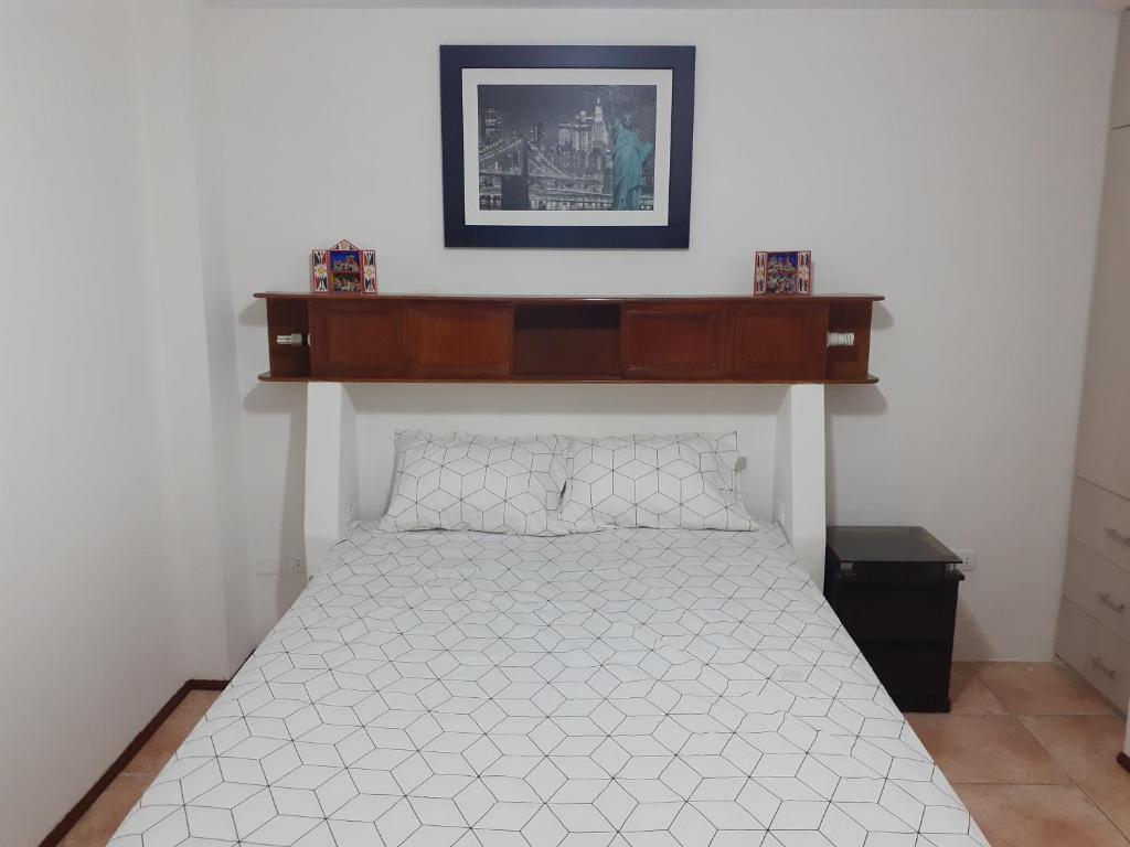 a bedroom with a bed with a wooden shelf above it at Inka Ayllu Hospedaje in Lima