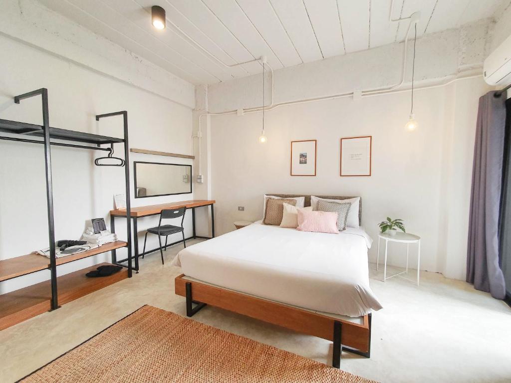 a bedroom with a bed and a desk in it at The51Hometel in Chiang Mai