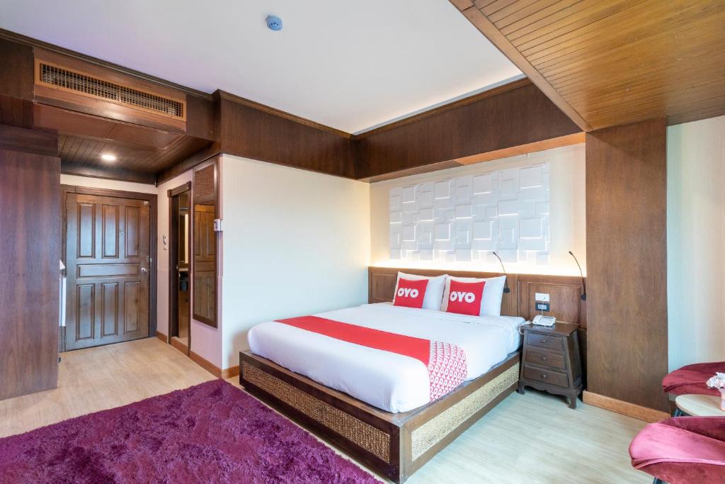 a bedroom with a large bed with red pillows at OYO 635 Sira Boutique Hotel in Chiang Mai