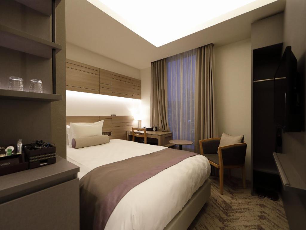 Postel nebo postele na pokoji v ubytování Nihon Seinenkan Hotel