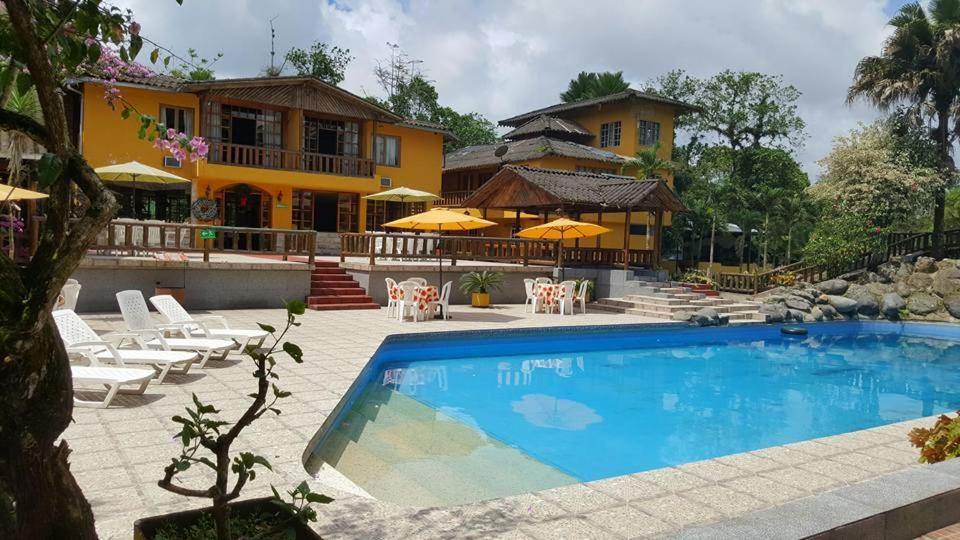 ein Haus mit einem Pool vor einem Haus in der Unterkunft Club Samawa in Santo Domingo de los Colorados