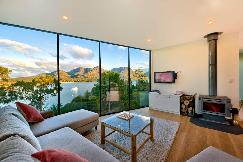 a living room with a view of a lake and mountains at Furneaux in Coles Bay