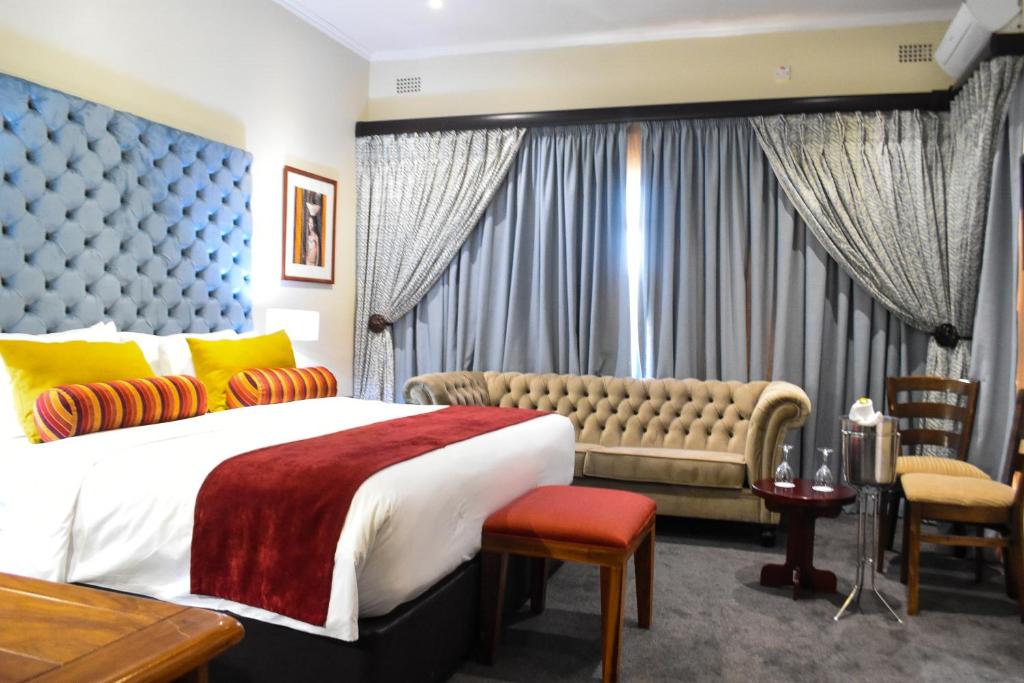a bedroom with a large bed and a couch at Cresta Botsalo Hotel in Palatswe