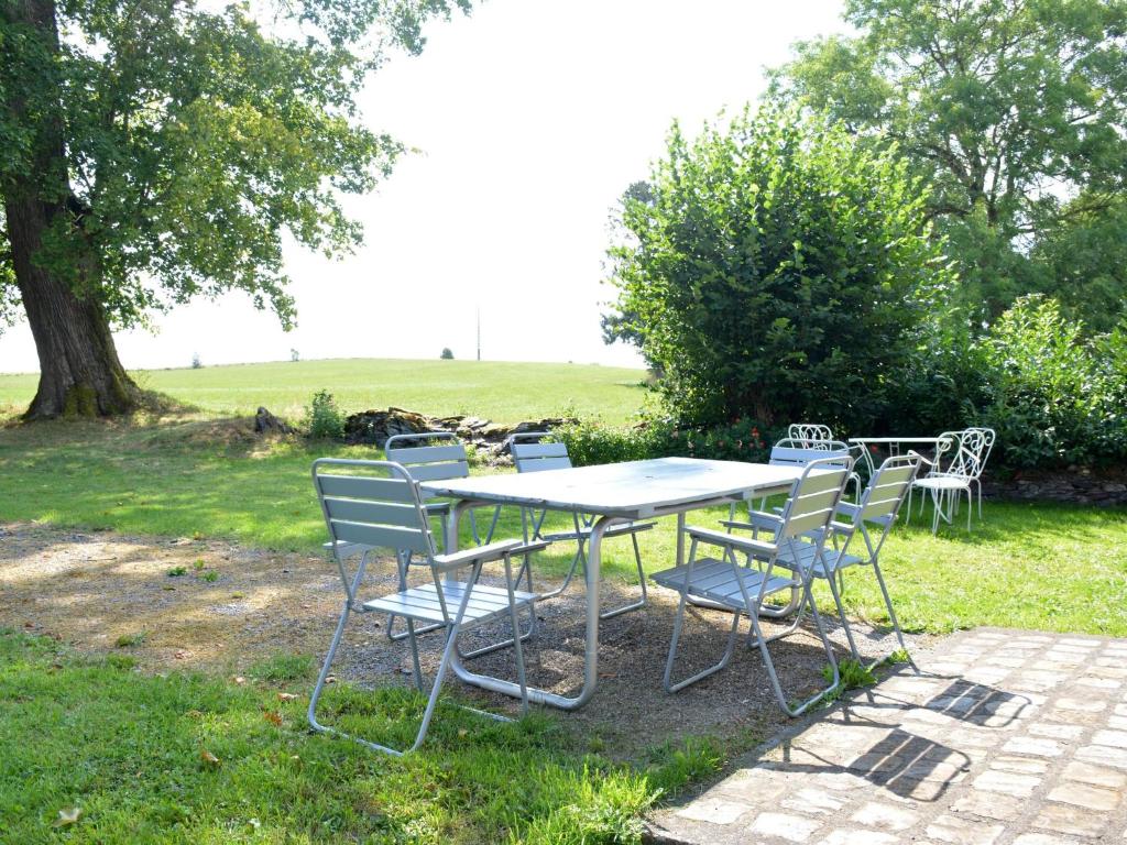 einen Tisch und Stühle in einem Hof mit einem Feld in der Unterkunft Beautiful Ardennes house in quiet area in Sainte-Ode