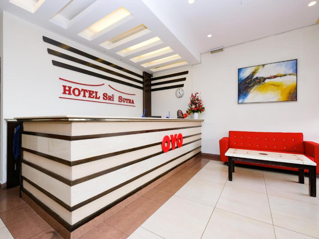 un hotel en el vestíbulo soleado con un banco rojo en OYO 89968 Sri Sutra Hotel en Petaling Jaya