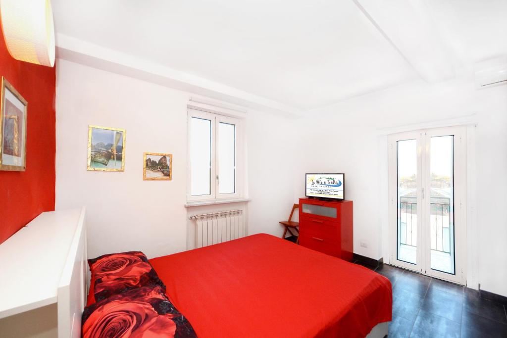 Habitación blanca con cama roja y TV en La vita è bella - Noli, en Noli