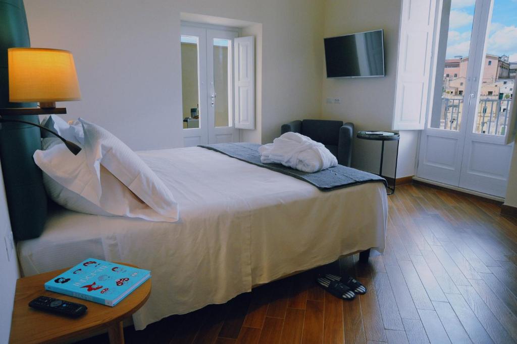 a bedroom with a bed and a table and a television at Dimora del Campo in Matera