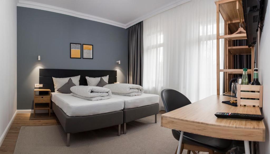 a bedroom with a bed and a desk and a table at Martin Boutique Hotel in Plauen