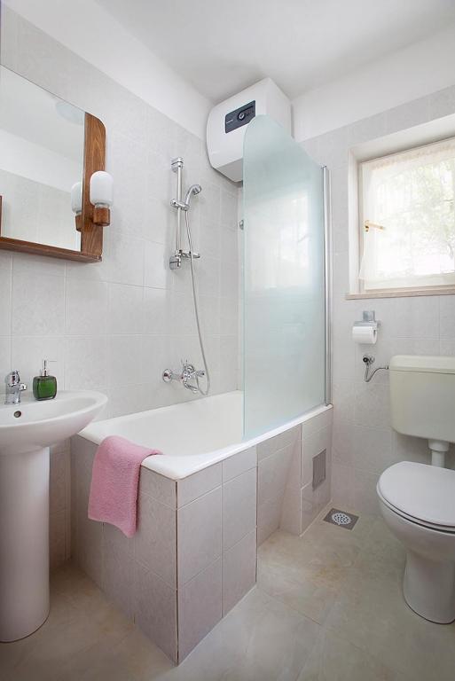 łazienka z wanną, umywalką i toaletą w obiekcie Apartments Eugen 2024 w Rabacu