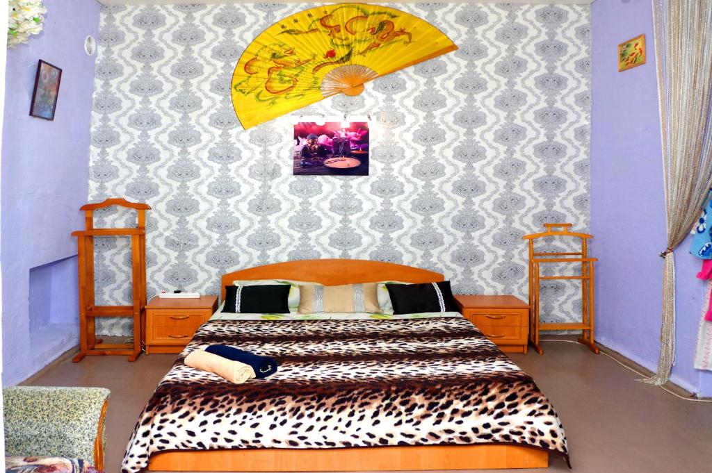 ein Schlafzimmer mit einem Bett und einem gelben Regenschirm in der Unterkunft Успенский in Odessa