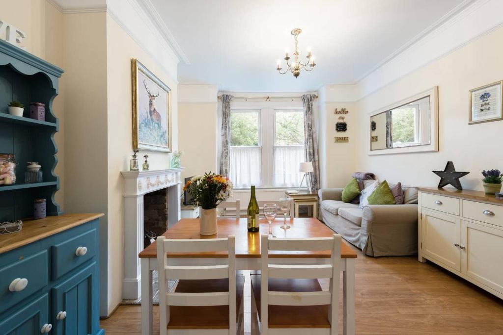 eine Küche und ein Wohnzimmer mit einem Tisch und einem Sofa in der Unterkunft Bikki Apartments - 2 Bedroom in Harrow