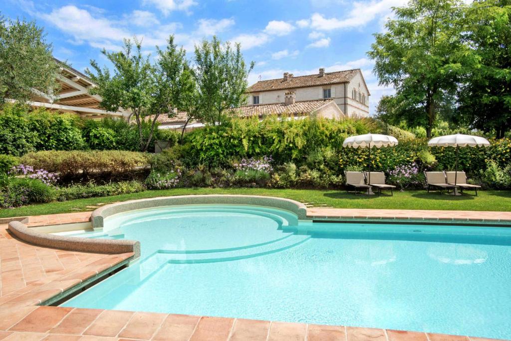 錫羅洛的住宿－Il Casale Di Giulia，一座带房子的庭院内的游泳池