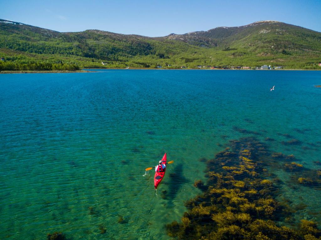 a person in a kayak in a large body of water at Tysfjord Hotel in Storjord I Tysfjord