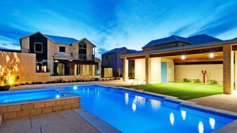 a large swimming pool in front of a house at Villa Serenity On The Terrace in Mandurah