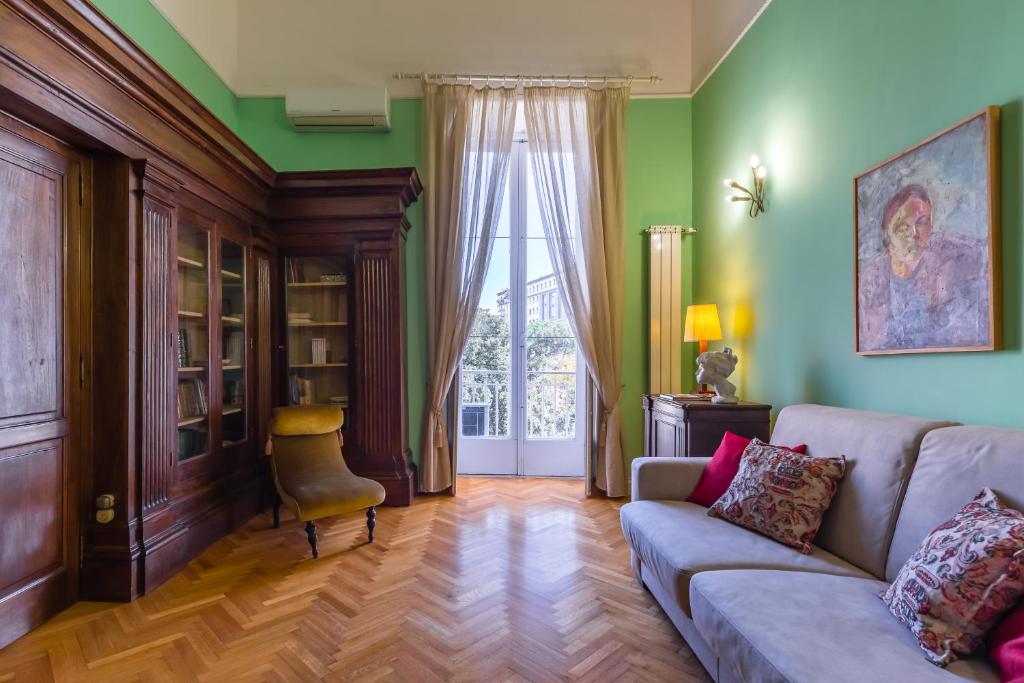 a living room with green walls and a couch at Appartamento a Piazza Cavour by Wonderful Italy in Naples