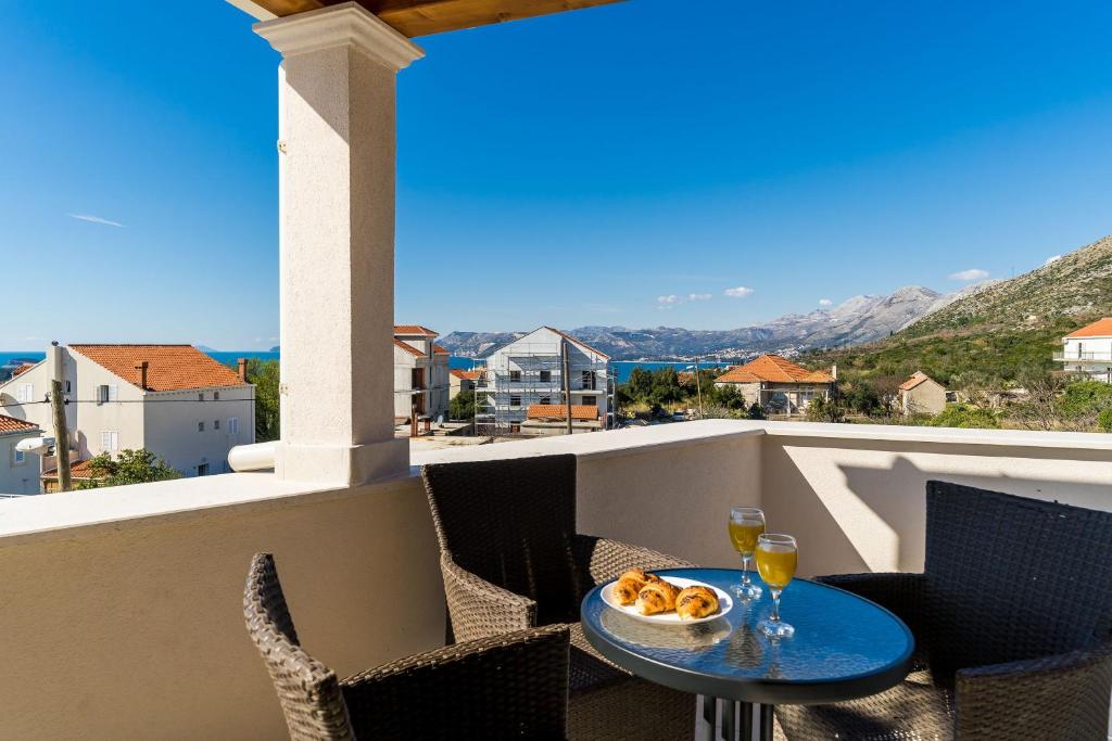 un tavolo e sedie su un balcone con vista di Apartments Šmanjak a Cavtat