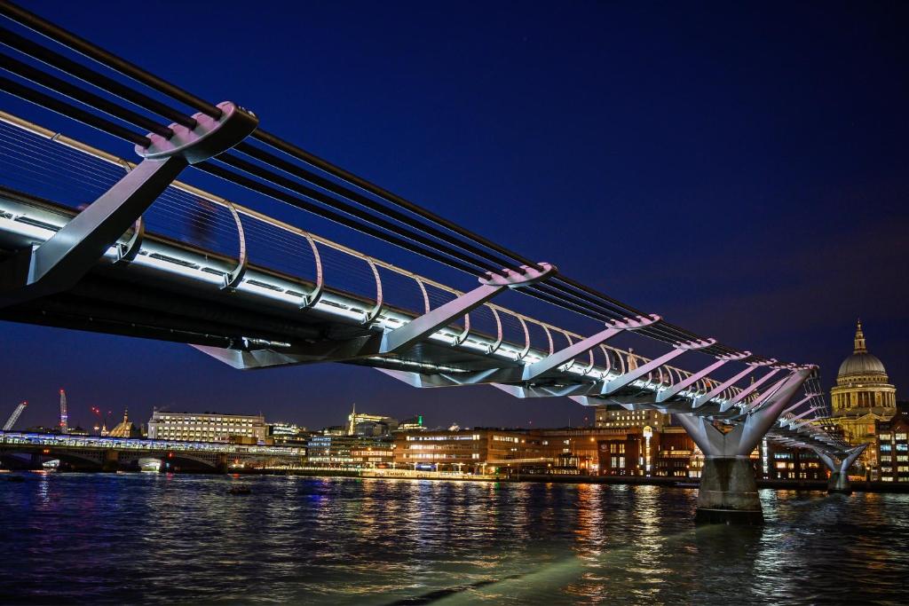 eine Brücke über das Wasser mit einer Stadt in der Nacht in der Unterkunft Room in Central London Overview Thames in London