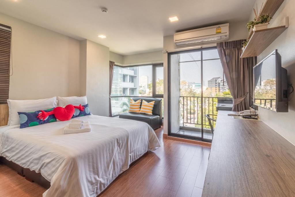 a bedroom with a large bed and a balcony at Casa Luxe Hotel and Resident in Bangkok