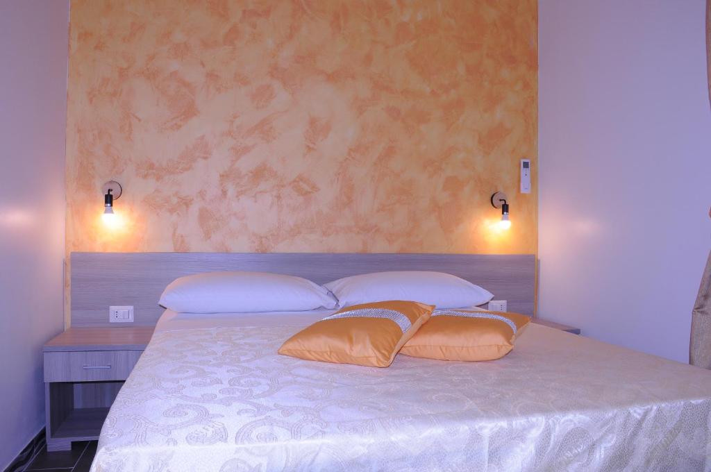 um quarto com uma cama com duas almofadas em La Fenice em Lampedusa