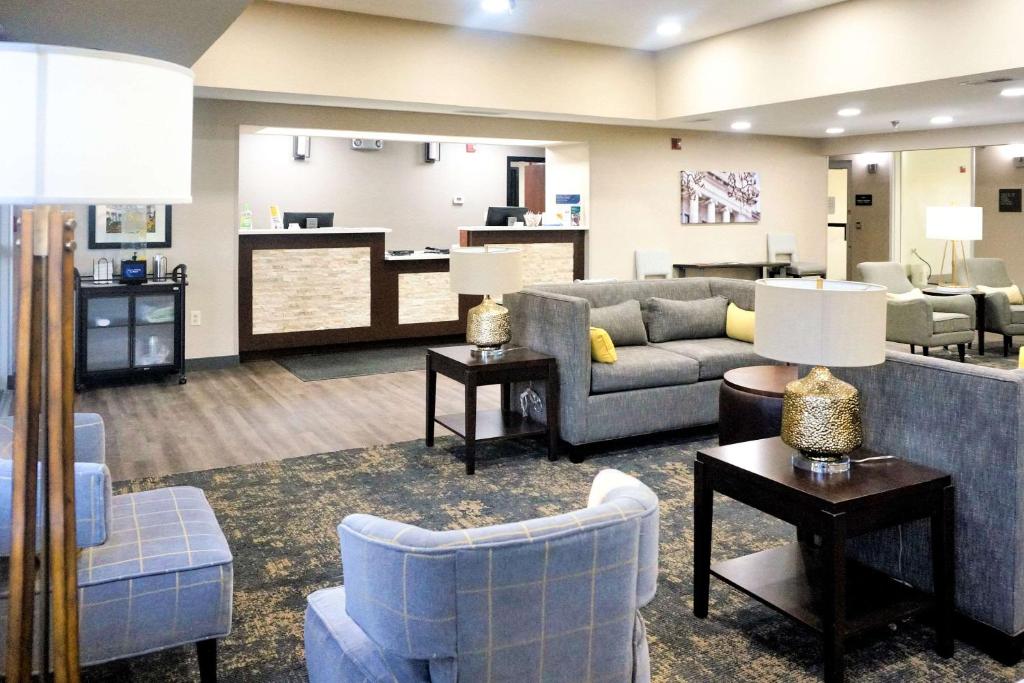 Comfort Inn & Suites Conway في كونوي: غرفة معيشة بها كنب وكراسي ومطبخ