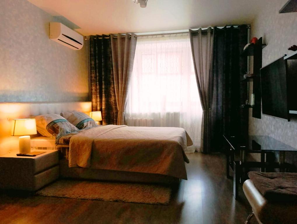 a bedroom with a large bed and a window at Apartment on Lenina 49 in Salihorsk