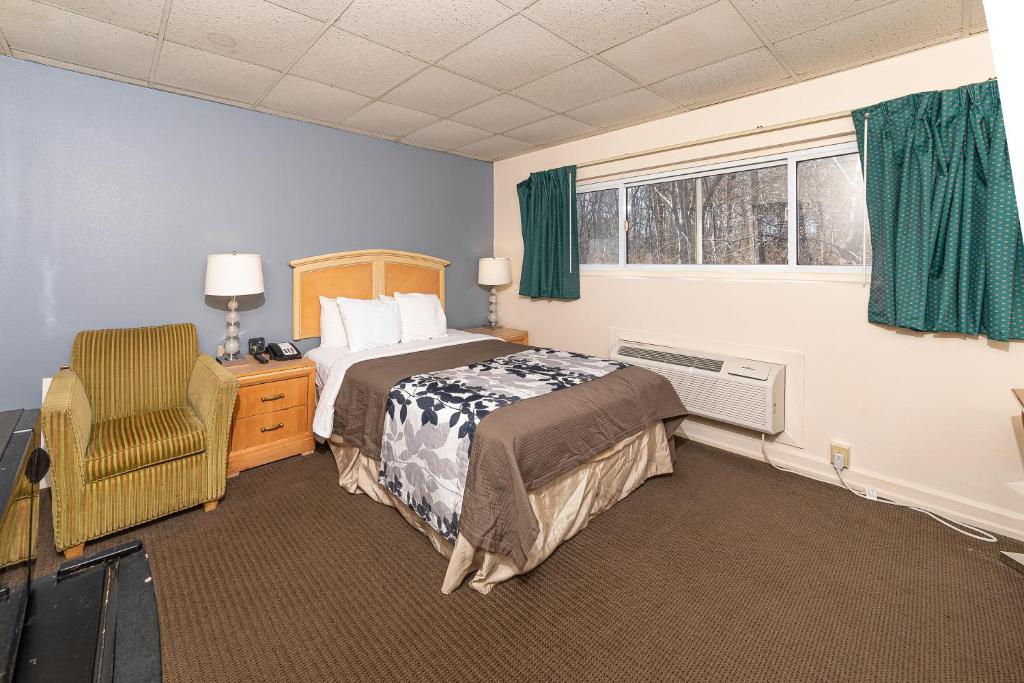 - une chambre avec un lit, une chaise et une fenêtre dans l'établissement Bedford Motel, à Bedford