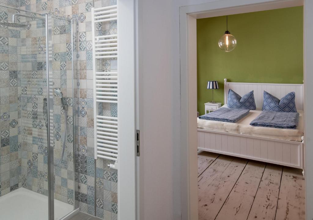 uma casa de banho com uma cama e uma cabina de duche em vidro em Pension Onkel Ernst em Naumburg