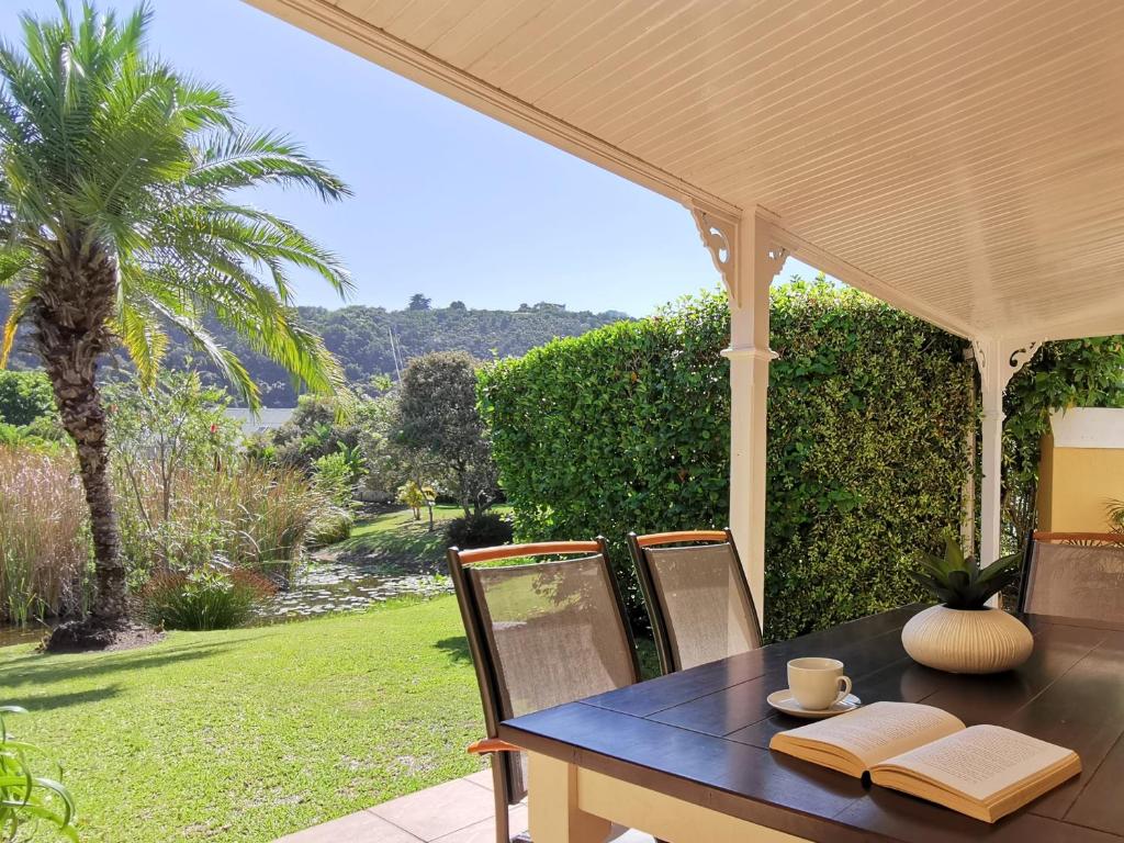 a table and chairs with a view of a garden at River Club 4213 in Plettenberg Bay