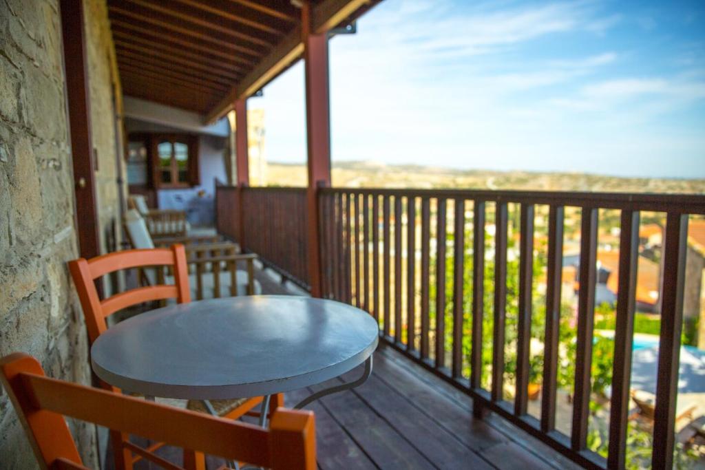 a table and chairs on a balcony with a view at Eveleos Country House in Tochni