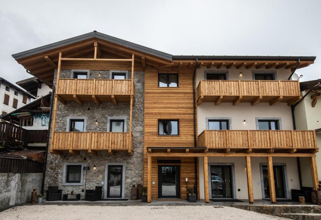 una grande casa con balconi in legno di Osteria Da Alvise a Sùtrio