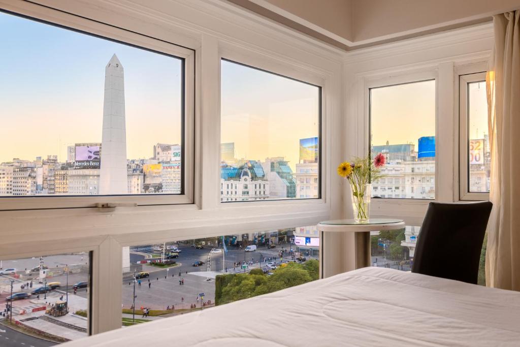 Schlafzimmer mit einem großen Fenster mit Stadtblick in der Unterkunft Exe Hotel Colón in Buenos Aires