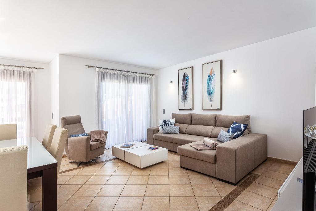 ein Wohnzimmer mit einem Sofa und 2 Stühlen in der Unterkunft Villa Simone by Intiholidays in Quarteira