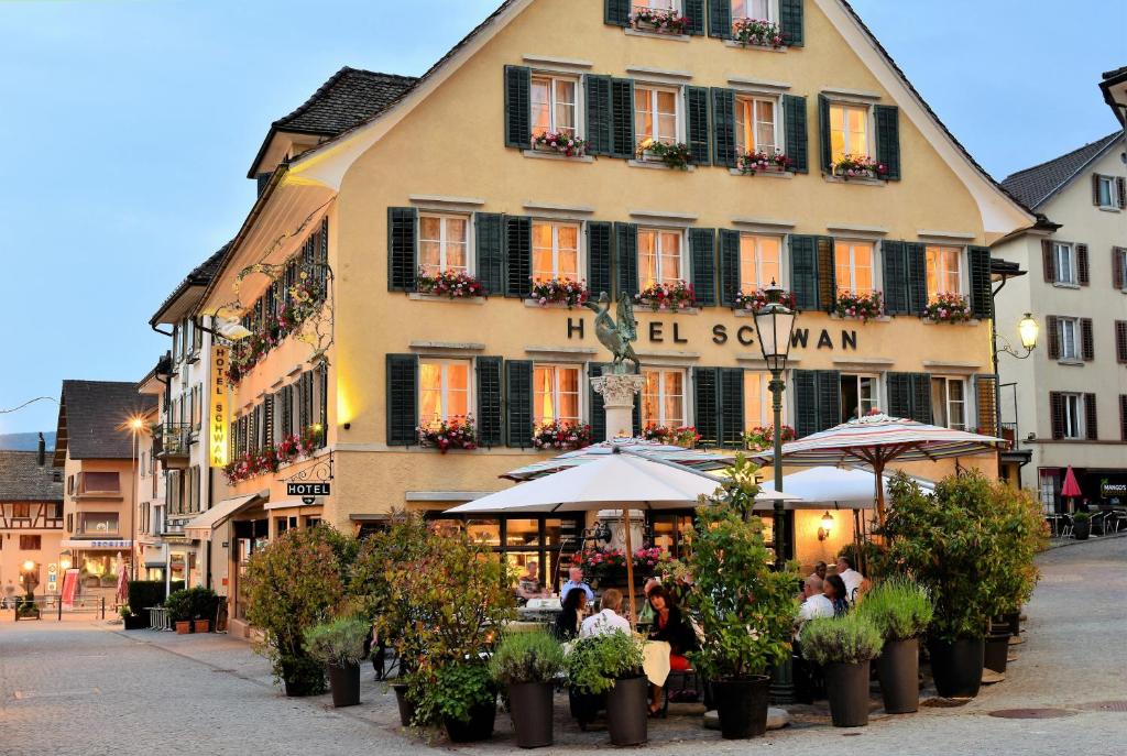 a large building with people sitting outside of it at Romantik Hotel Schwan in Horgen