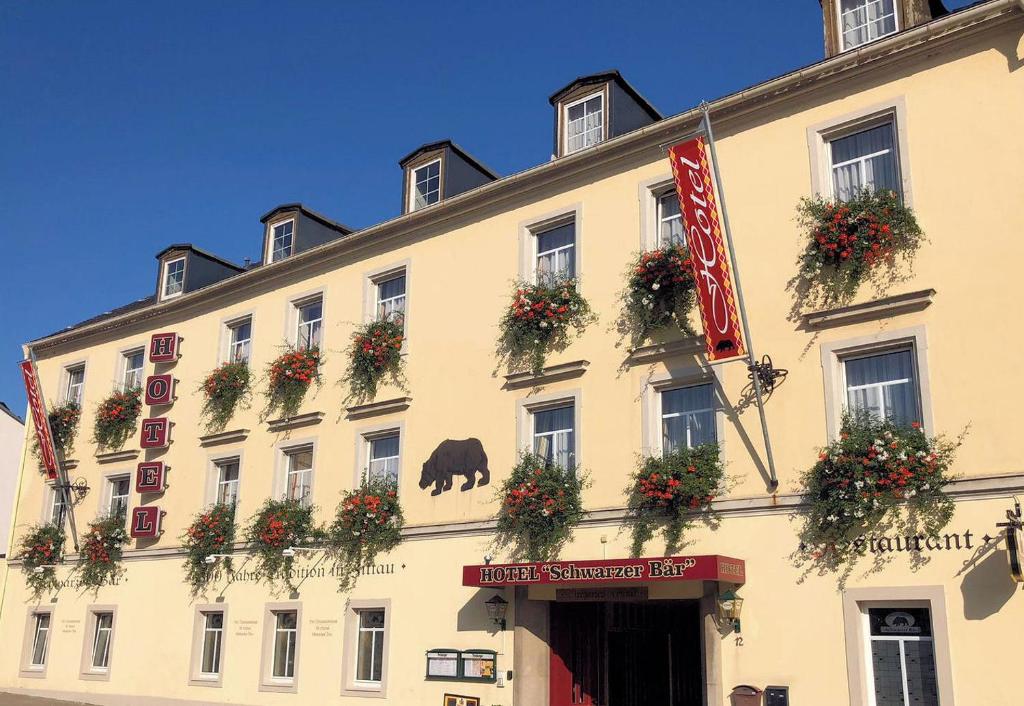 a large white building with flower boxes on it at Hotel Schwarzer Bär in Zittau
