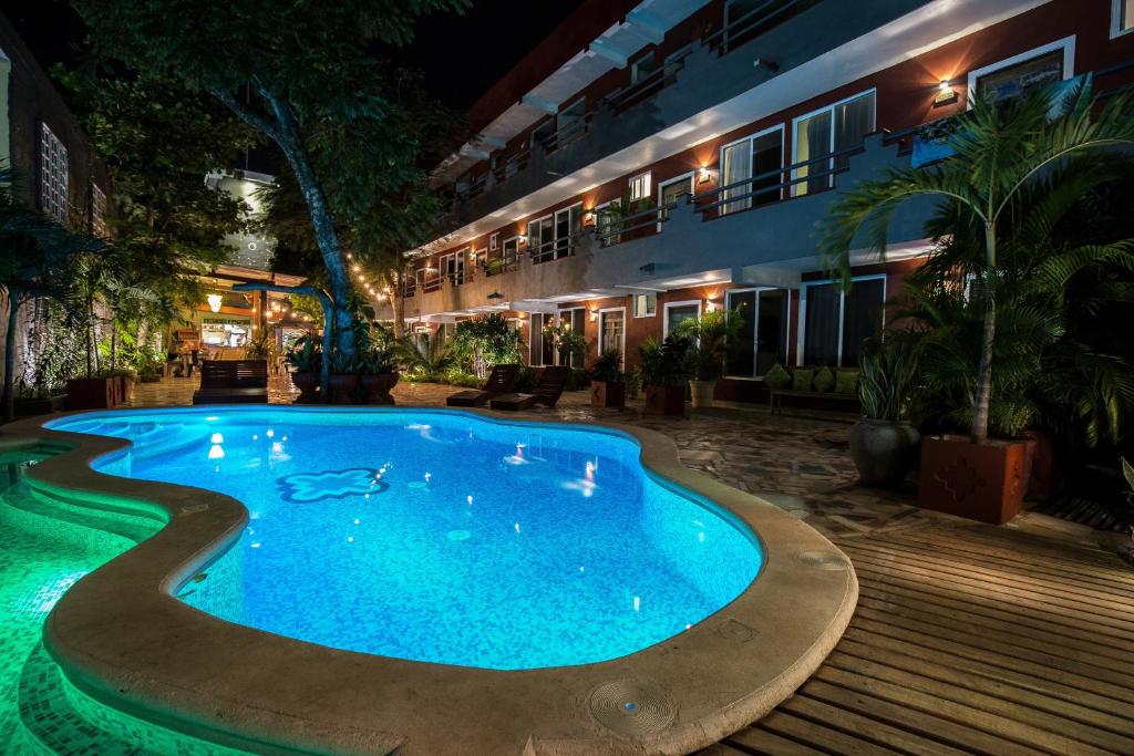 a swimming pool in front of a building at night at Casa Colonial Tulum in Tulum