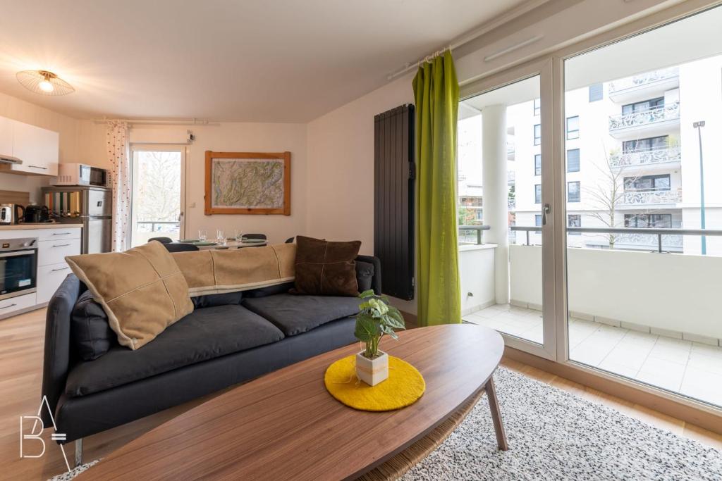 un salon avec un canapé et une table dans l'établissement L’Esperluette - 44 sqm apartment with garage & balcony in the city center, à Annecy
