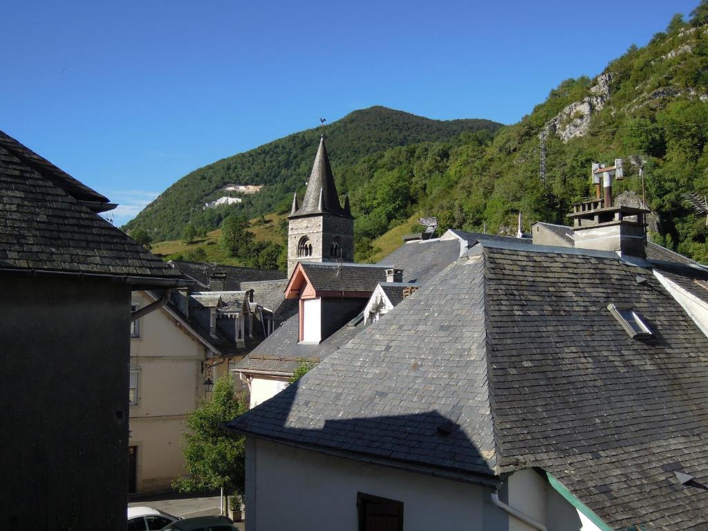 a group of roofs of buildings with a church at PAS à PAS CHAMBRE D'HOTES in Sarrancolin