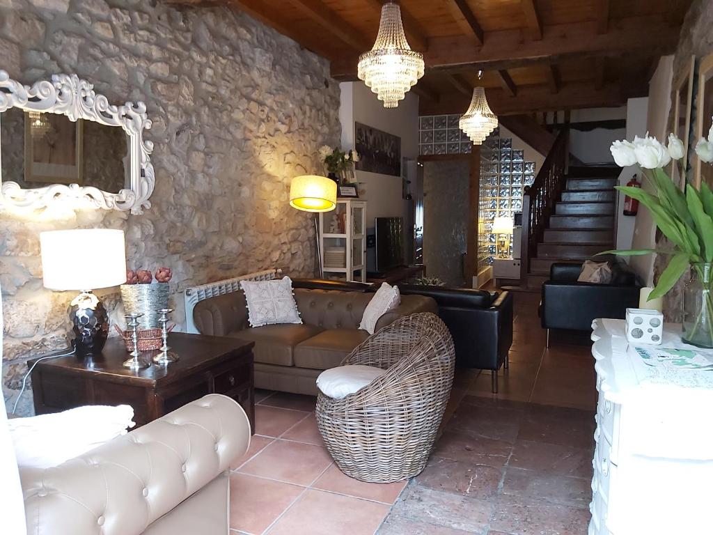 a living room with couches and a stone wall at El Juacu in Llanes