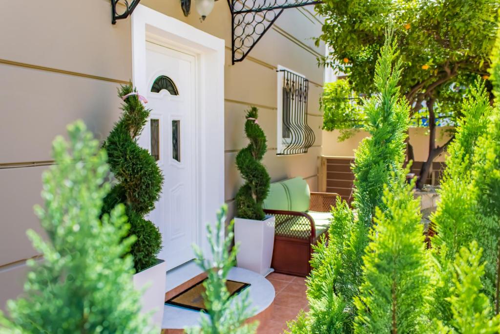een veranda met een witte deur en groene planten bij Villa Galata in Galatás