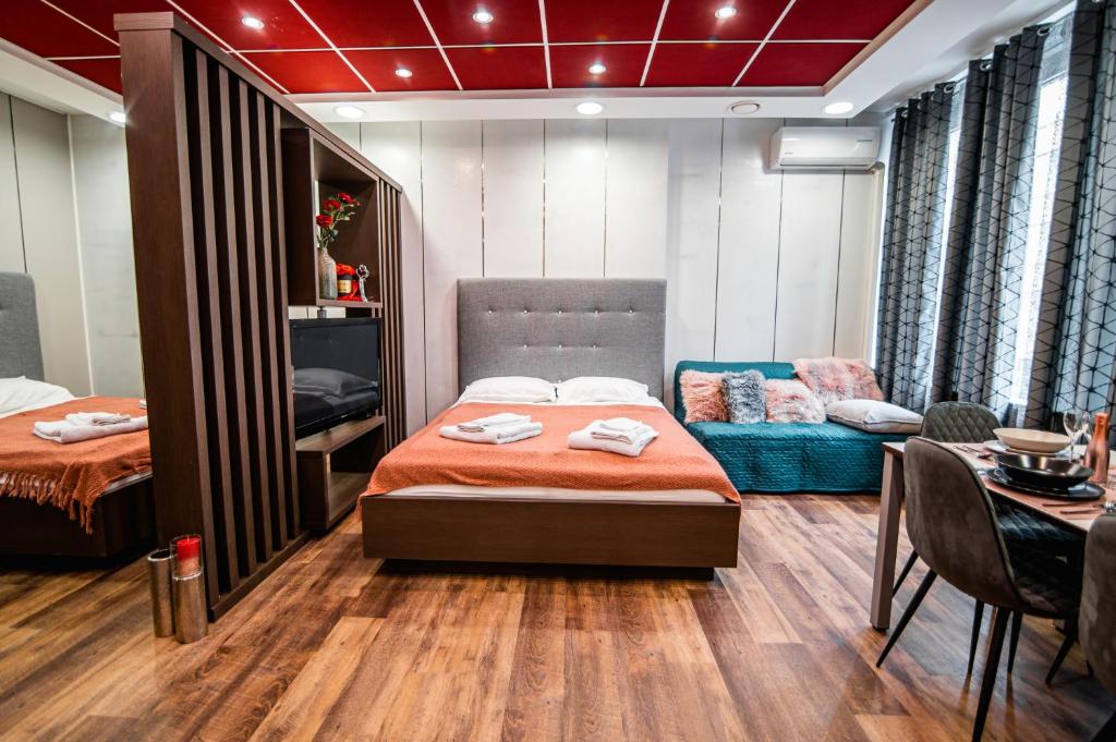 a bedroom with a bed and a couch and a table at Oxford Apartments in Ljubljana